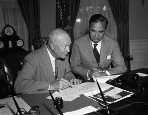 Original caption: Washington, D.C.:  Senator Prescott Bush looks on as President Eisenhower approves his bill which provides for a survey of the East Coast of the U.S. to see what measures could be taken to prevent future hurricane damage. June 15, 1955 Washington, DC, USA